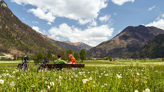 Urlauber pausieren auf blühenden Wiese im Val di Fiemme