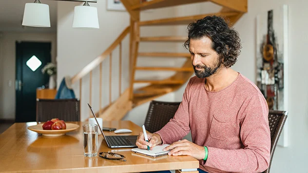 Workation auf der Ostseeinsel Poel - Bild: TMV/Gross Ein Mann arbeitet im Ferienhaus auf Poel an seinem Laptop.