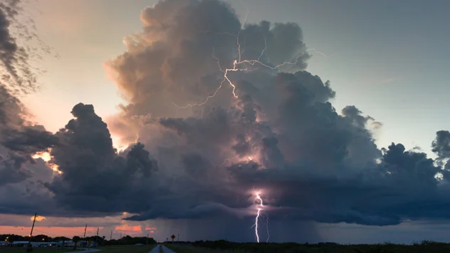 Eine Gewitterwolke im Abendlicht spuckt Blitze aus.