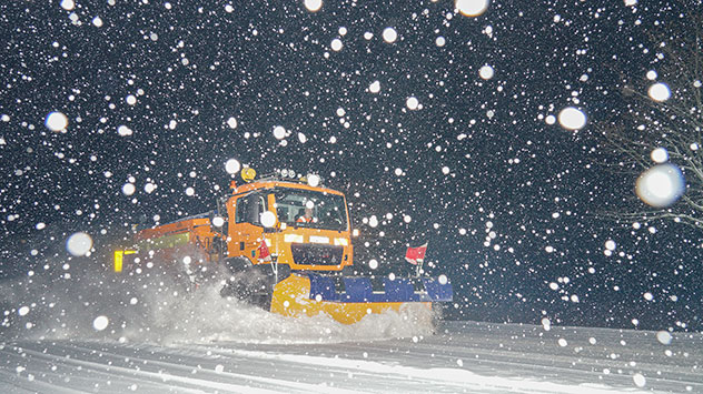 Winterdienst bei Nacht im Schneefall