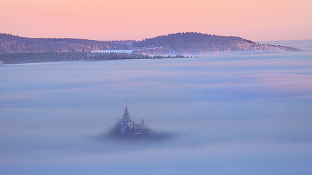 In Winterberg schaut die Kuppe mit der Kapelle wie eine Insel aus dem Nebelmeer heraus.