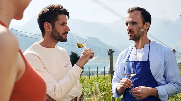 Personen bei der Weinprobe im Weinberg