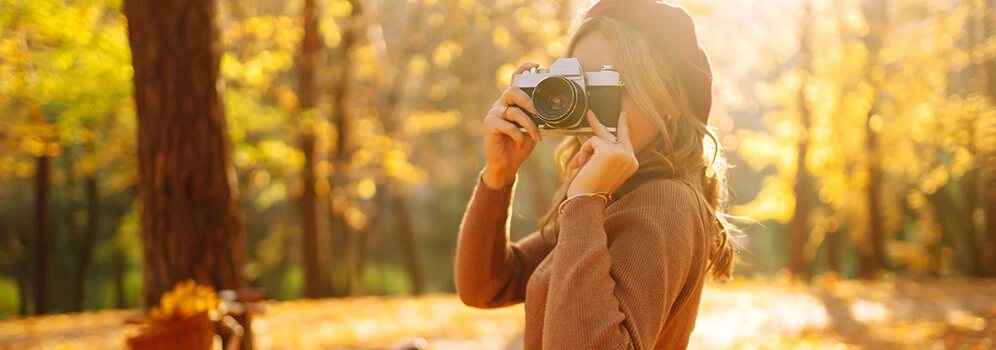 Frau fotografiert den Wald im Herbst