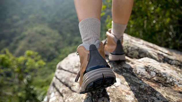 Lange Socken und festes Schuhwerk beim Wandern als Schutz gegen Zecken