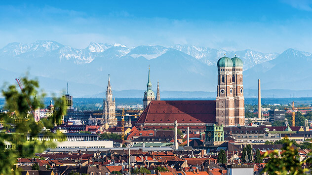 Blick über die Münchener Innenstadt und die Frauenkirche bis zu den Alpen