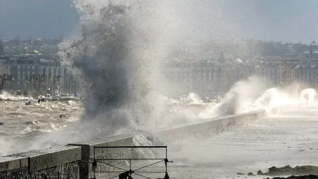 Die starke Bise wühlt den Genfer See ordentlich auf. Wellen klatschen an die Uferpromenade in Genf.