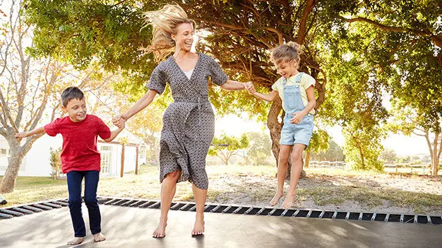 Frau mit zwei Kindern springt Trampolin