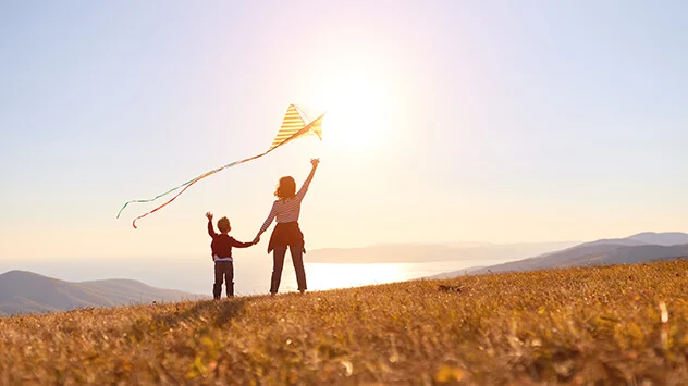 Outdoor Aktivitäten Im Herbst: Drachen steigen lassen Kinder lassen Drachen steigen auf einem herbstlichen Feld