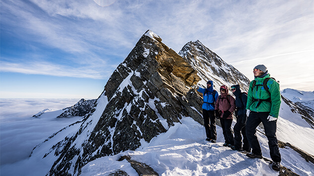 Wanderer genießen die Aussicht auf die schneebedeckten Berge vom Lagginjoch