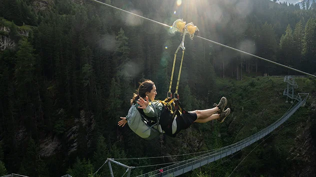 Eine Frau genießt die Fahrt auf dem Ischgl Skyfly. 