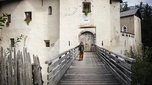 Schloss Welsberg: Sehenswürdigkeiten in Gsiesertal-Welsberg-Taisten - Bild: TG Gsiesertal / Silbersalz Brunhilde Rossi Agostini vor dem hölzernen Eingangstor von Schloss Welsperg