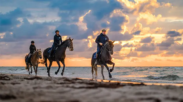 Reiter am Strand bei Sonnenuntergang