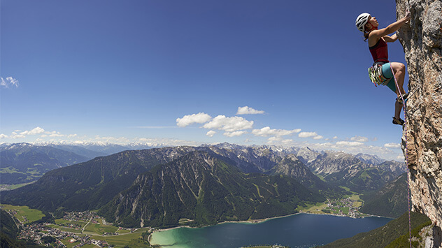 Kletternde Frau über dem Achensee