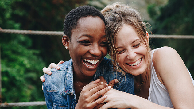 Zwei junge Frauen lachen und umarmen sich