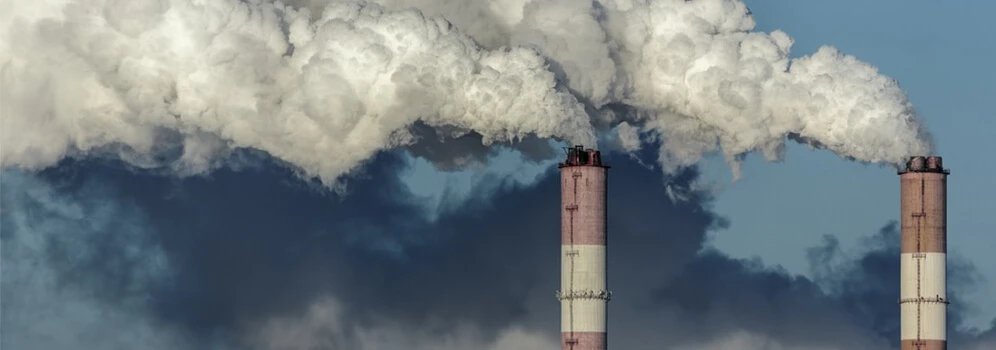 Fabrikschlote pusten Wasserdampf und Rußpartikel in die Atmosphäre.