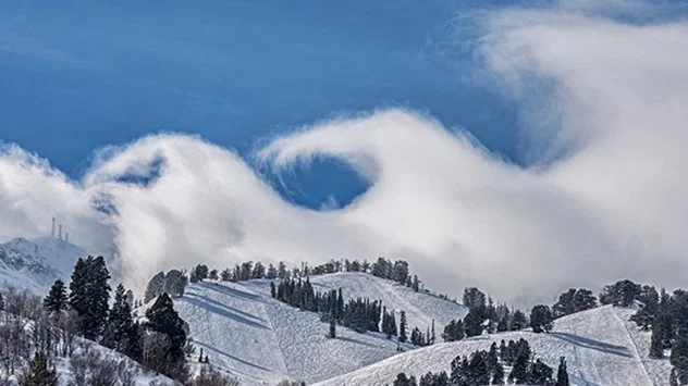 Kelvin-Helmholtz-Wellen über schneebedeckter Hügellandschaft
