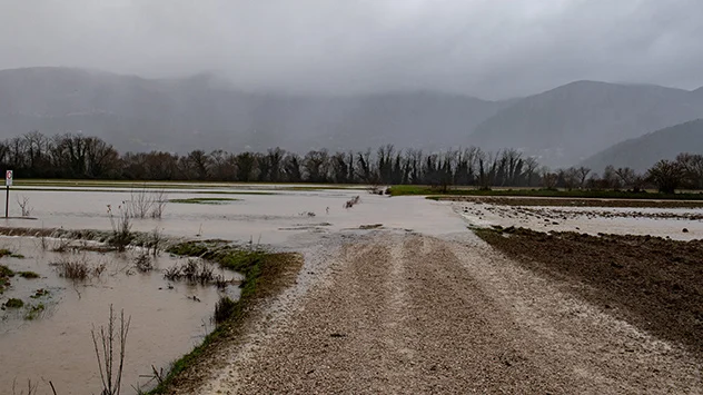 Dunkle Wolken und Regen im Apennin, überflutet Weg und Hochwasser