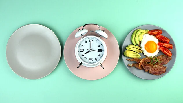 Ein leerer Teller, ein Teller mit einer Uhr und ein Teller mit einer Mahlzeit