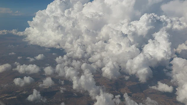 Luftaufnahme zeigt Cumulonimbus-Wolke neben kleineren aus Cumulus-Wolken.