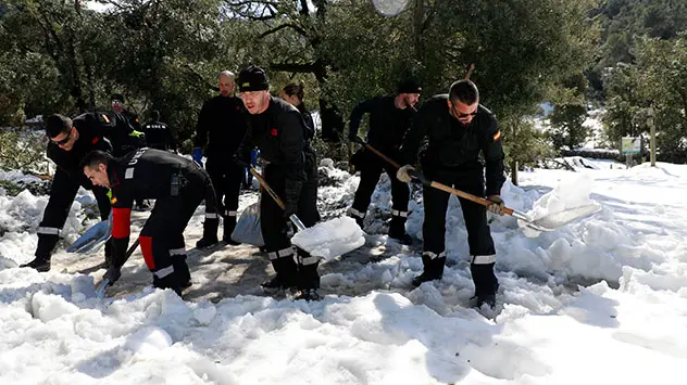 Männer schaufeln in Lluc Schnee weg