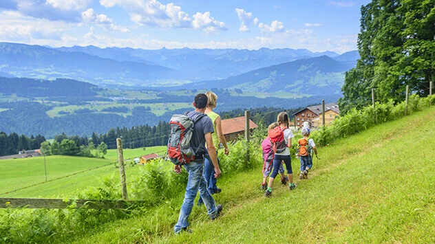 Familie wandert durch grüne Berge