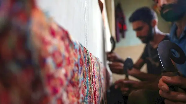Kashmiri artisans working on a handmade carpet