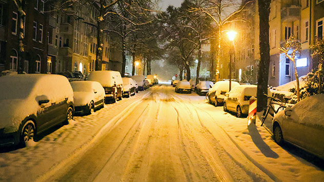 Parkende Autos sind nach starkem Schneefall in der Kieler Innenstadt mit Schnee bedeckt.