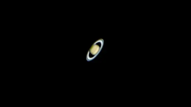 De planeet Saturnus met de vele ringen zichtbaar door een telescoop.