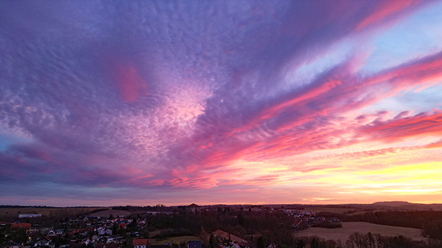 Panorama vom Ostharz über weites Land mit violett leuchtenden Wolken nach Sonnenuntergang