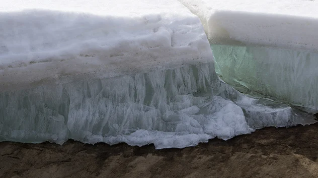 In einem großen Eisblock sind dauerhaft gefrorene Schichten zu erkennen.