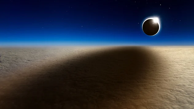 Der Mond wirft einen riesigen Schatten auf eine geschlossene Wolkendecke.