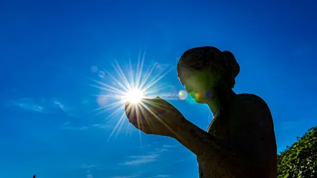 Blauer Himmel über Nordhessen - Statue scheint Sonne in der Hand zu halten.