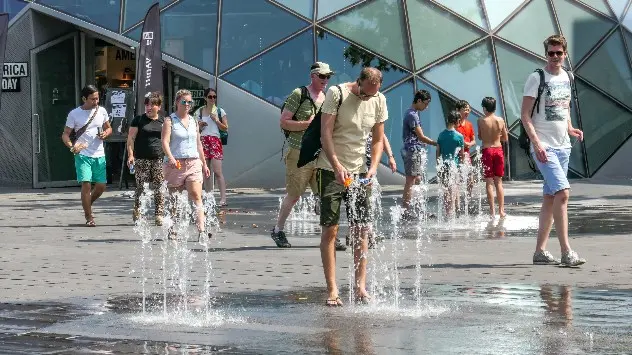 Ein Mann kühlt sich mit Wasser ab. 