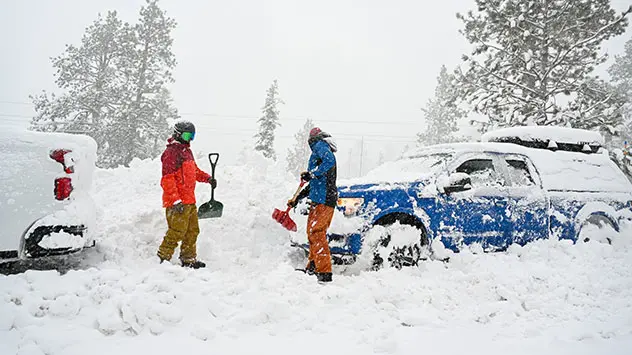 2 Männer schaufeln ihre Autos von den Schneemassen in Kaliforniens Bergen frei