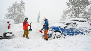 2 Männer schaufeln ihre Autos von den Schneemassen in Kaliforniens Bergen frei (c) dpa