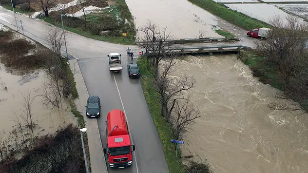 Felder überschwemmt, Kanal übervoll, über Brücke schwappend,  Autos auf Straße