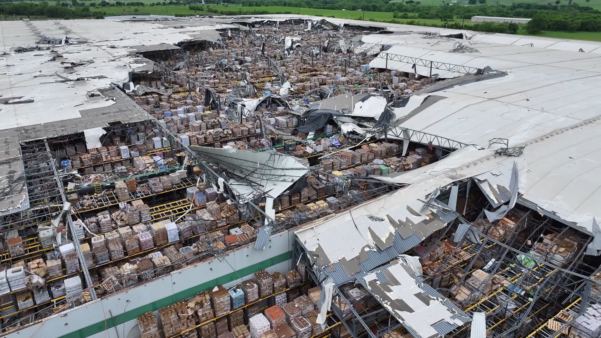 Top view of a multi-story Dollar Tree distribution warehouse heavily damaged after a tornado.