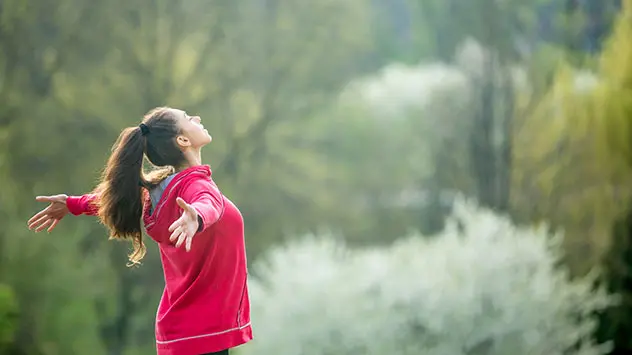 Eine Frau atmet beim Sport zur Entspannung tief ein