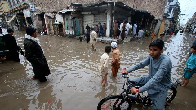 People wading through the flooded streets of Peshawar, Pakistan on Monday 15th April.