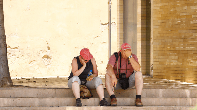 Unos turistas sofocados por el calor descansan a la sombra en Córdoba el pasado mes de junio.