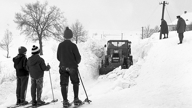 Ein Traktor kämpft sich durch über zwei Meter hohe Schneewehen. Vor allem in den ländlichen Regionen sind die Menschen oft auf sich allein gestellt.
