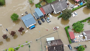 Häuser unter Wasser, Rettungsboot der Feuerwehr fährt durch die Fluten