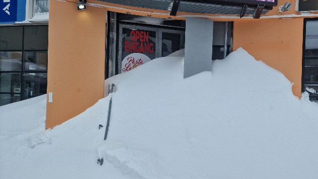 Vor dem Eingang eines Restaurants liegen enorme Schneemengen.