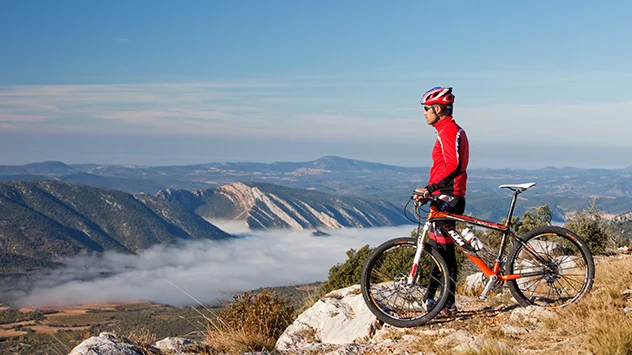 Fahrradfahren in Katalonien Ein Fahrradfahrer blickt auf die Gipfel der Pyrenäen