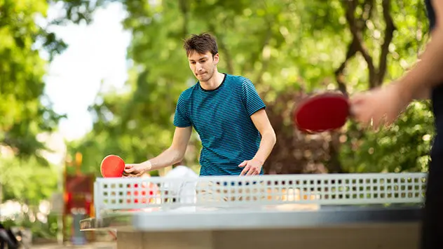 Junge Leute spielen Tischtennis im Park