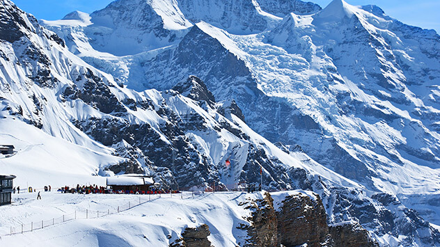 Verschneite Hütte vor hohen Bergen