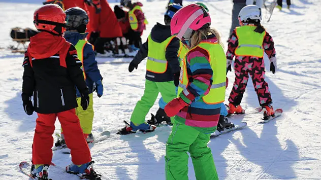 Kinder lernen Skifahren im Gruppenunterricht