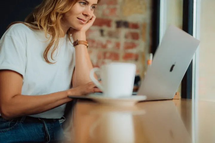 Female engineer working at her laptop in a coffee shop