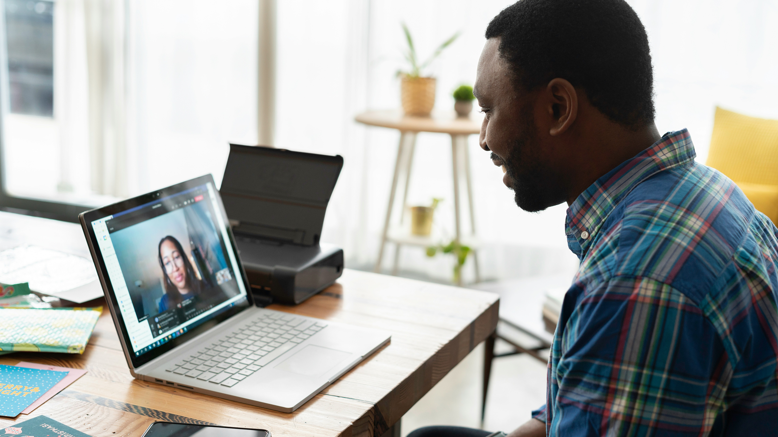 Image of two people meeting over a video conference call on a laptop