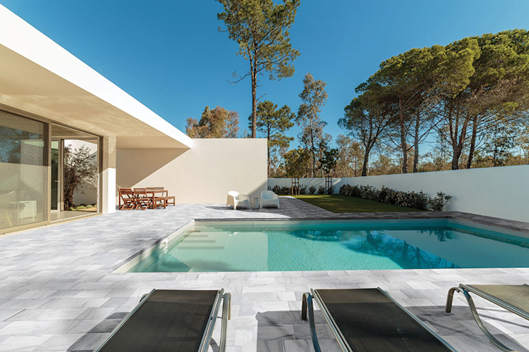 A large swimming pool is surrounded by a wooden deck